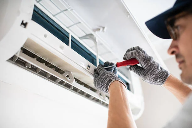 Technician securing components inside a wall-mounted air-conditioning unit