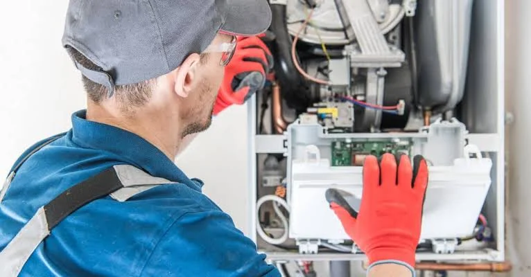 Service technician inspecting the internal components of heating equipment