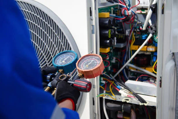 Technician checking refrigerant pressure with gauges during HVAC maintenance